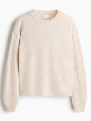 Beige stickad tröja med rund hals - Mysig beige stickad tröja med rund halsringning och långa ärmar. Tröjan har ribbade muddar vid ärmslut och nederkant, perfekt för lager på lager under kyliga dagar. Enkel och stilren design som passar till det mesta.