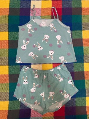 2-delad pyjamas H&M - Bilderna visar tre olika pyjamas-set med shorts och topp. Första setet är mintgrönt med kaninmönster och andra är ljusblått med små blommor. Den ljusblå pyjamasen med lång arm kommer från H&M. Bra skick, de blå pyjamasshortsen är något urtvättade men fungerar givetvis lika bra för det!! 