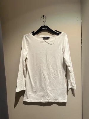 Vit långärmad tröja från KappAhl - En enkel och clean vit långärmad tröja från KappAhl i storlek XS. Tröjan har rund halsringning och är gjord i mjuk bomull, 