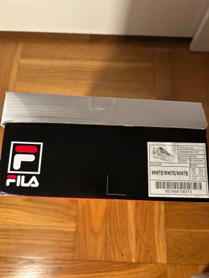 Fila Disruptor II Patch sneakers vita - Säljer ett par Fila Disruptor II Patch sneakers i helvitt med chunky plattformssula och snörning. Skorna har Fila-logga på sidan och tungan, samt extra patch medföljer. Tillverkade i syntetmaterial med cool retrostil och robust design. Strl i lagret: 37.5 och 38