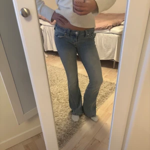 Ljusblå bootcut jeans låg midja - Snygga ljusblå jeans med bootcut och låg midja från true religon. De är knappt använda och skicket är väldigt bra! Jag är 171 cm lång. Orginal pris runt 1300 kr. Priset går att diskutera vid snabb affär!