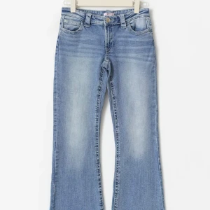 Bootcut ljusblå jeans med fickdetaljer - Snygga bootcut jeans i ljusblå tvätt med klassiska fem fickor och markerade sömmar. Jeansen har en normal passform och är tillverkade i mjukt denim-material. Bakfickorna har coola sömdetaljer som ger extra stilpoäng. Perfekta för dig som gillar retrovibbar. Från Gina nypris 360kr väldigt populära jeans❤️strl 158 men passar mig som är 162  pris kan diskuteras. Andvända 1-2 ggr 