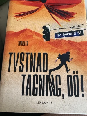 Tystnad, tagning, dö! - En actionfylld thriller med humor där Sam Milton hamnar mitt i Hollywoods filmvärld, jagad av mördare, korrupta poliser och giriga bolag. Perfekt för dig som gillar spänning, snabba vändningar och oväntade hjältar. En fristående fortsättning på Elddopet.