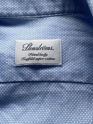 Blå skjorta från Stenströms, storlek 40 - Snygg blå skjorta från Stenströms i storlek 40 med diskret prickigt mönster. Tillverkad i tvåfaldig super bomull som känns mjuk och lyxig. Klassisk krage, vita knappar och långärmad modell. Perfekt för dig som gillar stilrena detaljer och kvalitetsmaterial. Om mi vill ha mer bilder är de bara att skriva!! Skjorta sitter som en Medium för nu så inte vet vad storlek 40 menas 