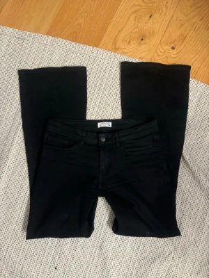 Lågmidjade bootcut jeans  - Svarta lågmidjade bootcut jeans från Lindex. En äldre Lindex modell och även ner sydda till extra lågmidjade. Storlek 164 men passar mig som brukar ha 34/W28