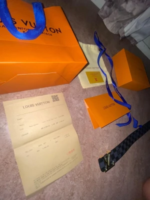 Louis Vuitton rutig skinnväst - Exklusiv väst från Louis Vuitton i svart och grått rutigt mönster med klassisk LV-logga i guld framtill. Västen har en stilren och modern design som sticker ut, perfekt för dig som gillar lyxiga detaljer och ikoniska märken. Materialet är skinn och ger en lyxig känsla. Kommer med kvitto och vi kan diskutera priset.