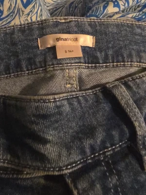 Blå jeans från Gina Tricot, S - Säljer ett par klassiska blå jeans från Gina Tricot i storlek S. Jeansen har dubbla knappar i midjan, fem fickor och snygg tvättad look. Perfekta till vardags och passar till det mesta. Materialet är slitstarkt jeans och modellen är figurnära.
