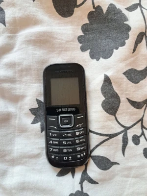 Samung GT-E1200 mobiltelefon - Samsung GT- E1200 mobiltelefon. En klassisk modell. Perfekt för den som söker en enkel och funktionell mobil. Perfekt för samlare eller den som vill återuppleva gamla tider.  Säljer i befintligt skick och som defekt/reservdelar. Inget batteri eller laddare medföljer Vet ej om den fungerar men misstänker att den gör det.  Skickas via posten men köpare står för frakten. Vid övriga frågor skicka meddelande.  Lämnar självklart god omdömen om köparen gör det.  Inget återköp eller retur om du går med 