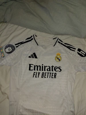 Real Madrid Jersey - Riktigt fin design och mönster och rekommenderas när man ska träna eller vara fysiskt aktivt. Storlek M, passar bäst som 175 elr lite kortare. Tvättas innan den köps. 