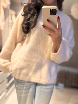 Beige/vit mohair  stickad tröja - Mysig och fluffig beige stickad tröja med rund hals och långa ärmar. Tröjan har en loose passform och är tillverkad i ett mjukt material som känns skönt mot huden. Perfekt för att hålla sig varm under kyliga dagar. Nypris låg på över 1000kr❣️