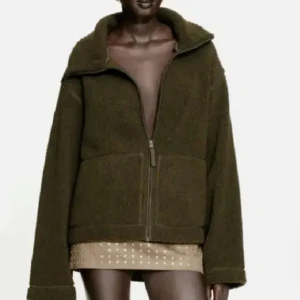 Olivgrön teddyjacka med dragkedja - Säljer en oversized olivgrön teddyjacka med stor krage och dragkedja framtill. Jackan är tillverkad i mjuk fleece och har långa ärmar samt en avslappnad passform. Perfekt för dig som vill ha en mysig och trendig look.