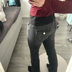 svarta bootcut jeans  - low waist bootcut med knappar på fickorna