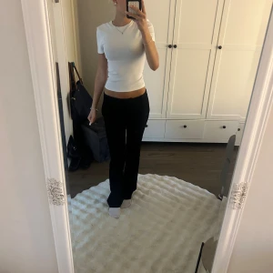 Vit croppad ribbad topp - Säljer en vit croppad topp med korta ärmar och rund hals. Toppen är ribbad och sitter tight mot kroppen, perfekt för dig som gillar en enkel och clean stil. Materialet känns mjukt och stretchigt, vilket gör den skön att bära hela dagen.