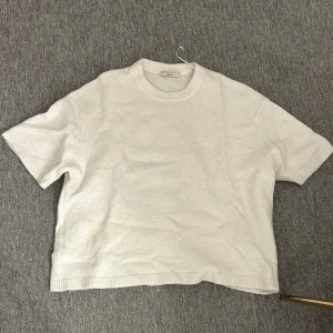 Vit stickad tröja från Gina Tricot - Vit stickad tröja från Gina Tricot med korta ärmar och rund halsringning. Säljer då den inte kommer till användning. Har använt den 3 gånger🥰.
