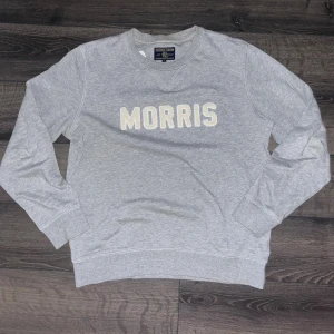 Morris Gents - Snygg grå sweatshirt från Morris Gents med broderad vit text på bröstet. Tröjan har rund hals, ribbade muddar och är tillverkad i mjuk bomull. Perfekt för en avslappnad och stilren look. Axelbrädd 43cm, längd 62cm. JAG SKICKAR INGA FLER BLIDER NÄR JAG BÄR PLAGGET PÅ:) s2 