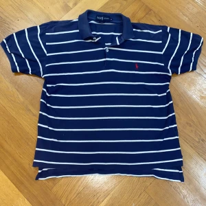 Ralph lauren piké  - Klassisk marinblå pikétröja från Ralph Lauren. En blandning av en sailors shirt och en polo, perfekt för sommaren. Den är i väldigt fint skick, inga slitningar eller missfärgningar. Skriv gärna om du har några frågor!😇