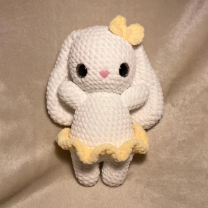 Virkad kanin med kjol och rosett - En virkad kanin med kjol och rosett, den är mjuk och gullig. Och stoppad med fyllnadsvadd, den har glittriga Säkerhetsögon och är virkad av mig!