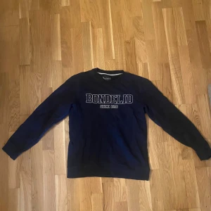 Mörkblå sweatshirt från Bondelid - Säljer en mörkblå sweatshirt från Bondelid med klassisk logga broderad framtill. Nypris 750kr