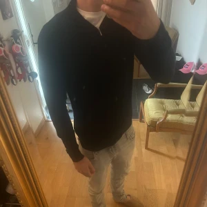 Svart merinoullströja half zip  - Svart långärmad tröja från Dressmann i mjuk merinoull. Tröjan har en stilren half zip-dragkedja vid halsen och en klassisk passform. Perfekt för lager-på-lager och funkar året runt när du vill ha en clean look. Storlek M, nypris 699kr 