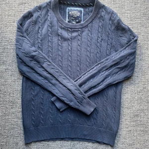 Mörkblå kabelstickad tröja Bondelid - Säljer en mörkblå kabelstickad tröja från Bondelid i storlek Small. Tröjan har rund halsringning, ribbade muddar och ett klassiskt kabelmönster. Perfekt för kyliga dagar och enkel att matcha med jeans eller kjol. Postar snabbt!!