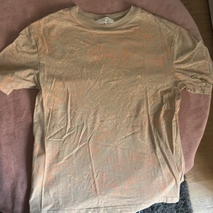 Beige blommig t-shirt från H&M - Säljer en beige t-shirt från H&M med blommigt mönster och texten 'Best Day' tryckt på framsidan. T-shirten är kortärmad och gjord i mjuk bomull, perfekt för en chill och avslappnad stil.