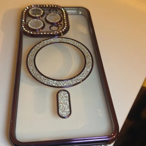 Glittrigt MagSafe skal till iPhone 14 Pro  - Elegant och glittrigt skal med MagSafe-kompatibilitet, designat för iPhone Pro Max. Skalets kanter och kameraskydd är dekorerade med strass och glitter, vilket ger ett lyxigt utseende. Skalet är i nyskick och fick även i present som köpte från 120kr men säljs för 45kr