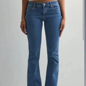 Blå low waist jeans - Så snygga blåa low waist jeans! De är slitna vid låret som som syns på bild två, men även slitningar längst ner vid benen på bild tre. Storlek xs/34
