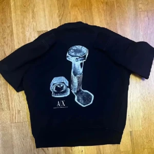 Armani Sweater - Snygg svart sweatshirt från Armani Exchange med unikt silvertryck. Loose fit, passar även Medium. Sparsamt använd och i superbra skick, inga skador.