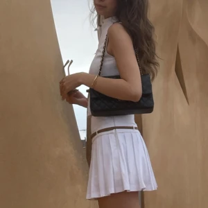 Vit set från Zara - Vit kortkjol med plisserad design och ett smalt brunt bälte i midjan. En topp i samma sätt med bälte också💗