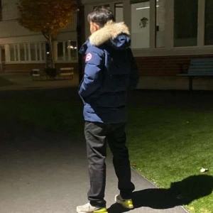 Mörkblå Canada Goose dunjacka med päls - Säljer en mörkblå Canada Goose dunjacka med äkta päls på huvan. Jackan har en klassisk parkamodell med lång ärm, dragkedja och flera fickor. Perfekt för kalla vinterdagar och har den ikoniska loggan på ärmen.