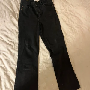 Svarta raka jeans med mid waist - Snygga svarta jeans med raka ben och klassisk femficksdesign. Mid waist och stilren look som passar till det mesta. Jeansen är tillverkade i ett mjukt och slitstarkt bomullstyg med dragkedja och knapp framtill.