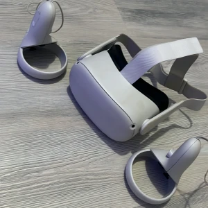 Oculus Quest 2 VR-headset - Oculus Quest 2 VR-headset med två handkontroller. Allt ser ut att vara i gott skick med endast mindre ytliga märken på handkontrollerna. Perfekt för trådlös VR-upplevelse hemma. Laddningskabel ingår ej.