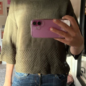 Olivgrön stickad tröja Flash Woman - Säljer en olivgrön stickad tröja från Flash Woman. Tröjan har en snygg strukturstickning med olika mönster på över- och underdelen samt trekvartsärmar. Den har en rund halsringning och en loose passform som är både chill och trendig.