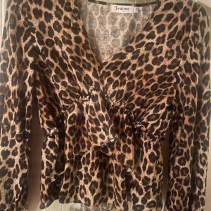 Leopardmönstrad omlottblus från J'aime - Säljer en snygg leopardmönstrad omlottblus från MISSÄY med volangdetaljer och v-ringning.