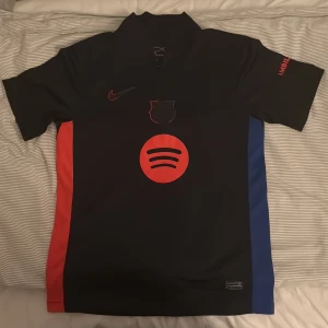 Svart FC Barcelona Nike fotbollströja - Säljer en svart FC Barcelona fotbollströja från Nike, mycket bra skick har använt den 1-2 gånger. På fjärde bilden har storleken gått bort från tvätten. 