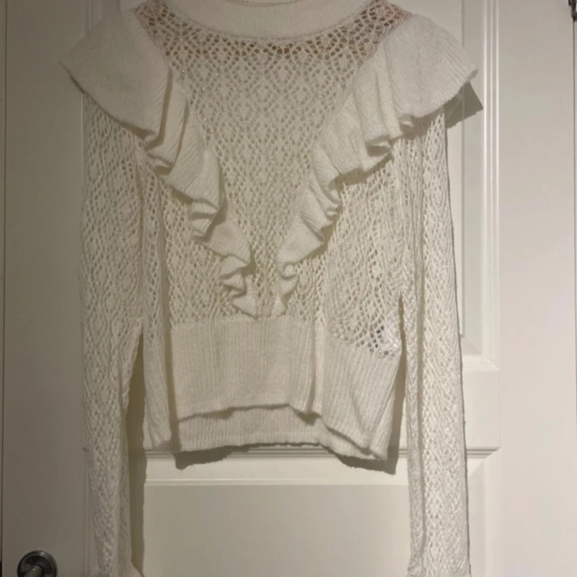 Vit stickad tröja med volangdetaljer