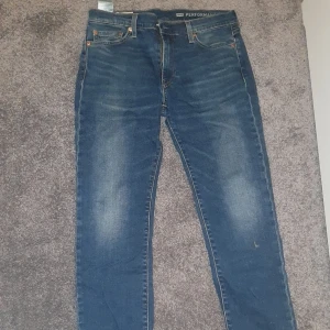 Levi's 511 blå jeans W30 L32 - Säljer ett par klassiska Levi's 511 jeans i blå denim. Modellen är slim fit med raka ben. Jeansen har 4 fickor och läderpatch bak i midjan. Perfekta för dig som gillar en tidlös och stilren look. Nästan helt oanvända,  hör av er om ni har frågor eller funderingar 