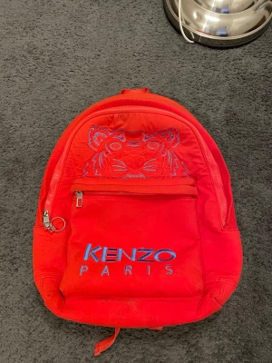 Röd ryggsäck från Kenzo - Köpt från kronofogden. En ryggsäck med mycket historia. PM vid frågor eller bud😊