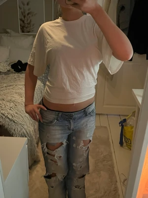 Vit kortärmad t-shirt  - Säljer en vit t-shirt med loose fit och korta ärmar. Modellen är enkel med rund hals och lite längre ärmar som ger en avslappnad vibe. Materialet känns som mjuk bomull och toppen är perfekt att styla med jeans eller shorts. Passar dig som gillar basic och clean stil🫶🏼