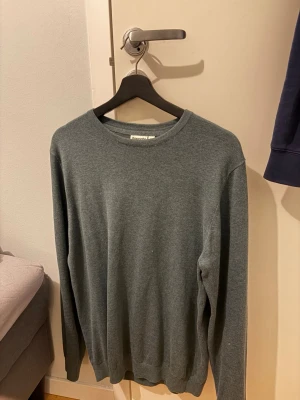 Grå/grön stickad tröja  - Säljer en stickad tröja med färgen grå/grön i storlek L men passar även M. Tröjan är finstickad och nästan oanvänd.