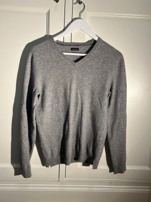 Grå kashmirtröja med v-ringning - En snygg grå 100% kashmire v ringad tröja i bra skick. Passar från 165-170 skulle jag säga kan bero på lite. Fint skick!