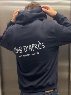 CLUB D’APRÈS - Club d’Après - den perfekta hoodien för afterski, stadsliv och allt däremellan. Simpel, mjuk och stilren.
