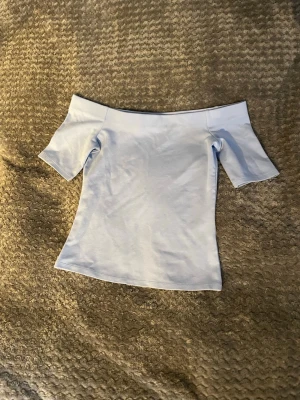Ljusblå offshoulder topp H&M XS - Säljer en ljusblå offshoulder topp från H&M i storlek XS. Toppen är tight (för mig) och har offshoulder. Helt ny utan prislapp har alldrig andvänts🩵🩵🩵
