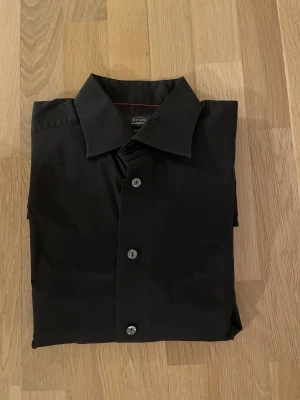 Svart skjorta från Eton Contemporary Fit - Snygg svart skjorta från Eton i Contemporary fit. Nypris ca 1700kr mitt pris endast 199 kr. Fraktar inom 1 dag, om du har någon fundering så är det bara att höra av sig😊