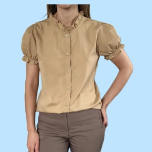 Beige kortärmad blus med puffärmar i XXS. NA-KD - -Beige kortärmad blus med puffärmar från NA-KD i storlek 32. -Oanvänd.