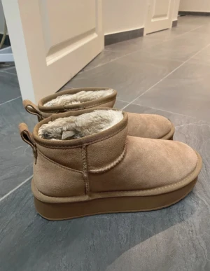 Snö boots med platå - Boots i ugg - stil (ej märket UGG®)  Äkta mocka. Lite dammiga på insidan annars helt nya i kvaliten. Använd några gånger. Skorna har inget märke.  Pris går att diskutera 😊
