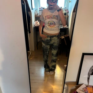 Unika blå vita tie dye vintage jeans - Unika jeans med blå och ljusbeige/ vit dye-effekt. Klassisk rak passform och femficksmodell. Jeansen har normal midja och är tillverkade i slitstarkt bomullsdenim. Perfekta för dig som vill sticka ut med en cool och trendig look.
