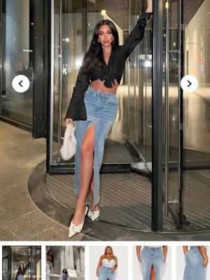 Ljusblå jeanskjol med hög slits - Trendig lång jeanskjol i ljusblå denim med en hög slits framtill. Kjolen har klassisk femficksdesign och rak passform som ger en snygg siluett. Perfekt att styla med boots eller klackar för en cool look.