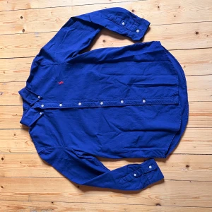 Blå skjorta från Ralph Lauren  - Klassisk blå skjorta från Ralph Lauren i relaxed fit, men är väldigt liten i storleken så passar väl xs kanske s i slimfit. Då förra ägaren antagligen tvättat den fel. Annars är den felfri