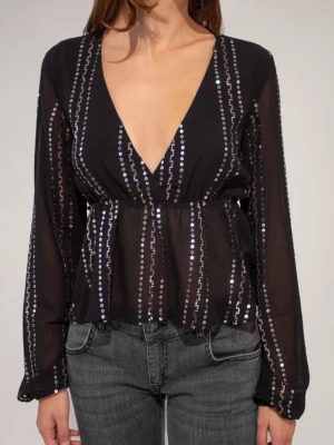 Svart paljettblus med v-ringning - Svart blus med djup v-ringning och långa ärmar. Blusen har rader av glittrande paljetter. Bara använd en gång. 